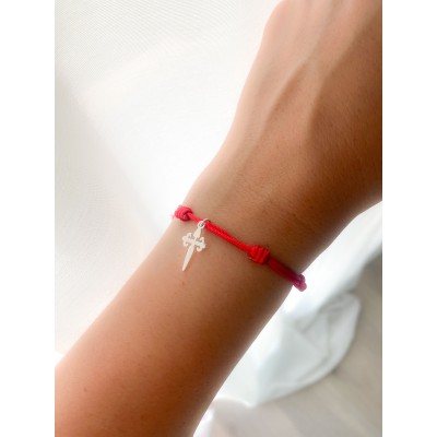 A red string bracelet with a gold-plated cross pendan